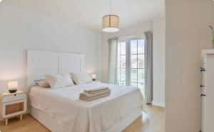a white bedroom with a bed with towels on it at El Rincón del Charco in Arrecife