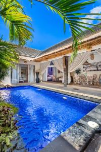 a swimming pool in front of a house at Villa deluna in Jimbaran