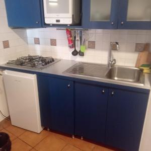a kitchen with blue cabinets and a stove and a sink at Tok Tok Taormina in Taormina