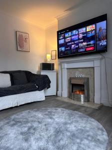 a living room with a television above a fireplace at Budget Rooms Lincoln City Centre , Fast WiFi & Self Check in in Lincoln