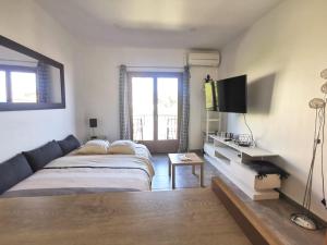 a bedroom with a bed and a television in it at Studio Serenity - Clim - WIFI - Parking - Piscine - Front de mer - Proche commerces et centre ville in Fréjus