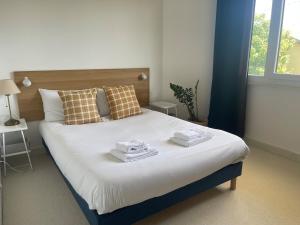 a bedroom with a large bed with towels on it at L'instant cocon in Beaumont