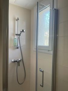 a bathroom with a shower with a glass door at L'instant cocon in Beaumont +6 photos