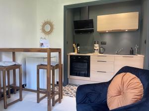 a living room with a couch and a kitchen at L'instant cocon in Beaumont