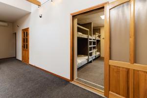 a hallway with a door and a room with bunk beds at Hang The Hat in Valmiera