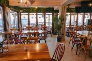a restaurant with tables and chairs and windows at Hotel Sunset Beach Vama Veche in Vama Veche