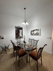 a dining room with a glass table and chairs at Cozy Disney Stay in Kissimmee +11 photos