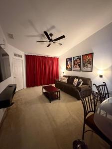 a living room with a couch and a ceiling fan at Cozy Disney Stay in Kissimmee