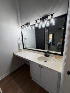a bathroom with a sink and a large mirror at Cozy Disney Stay in Kissimmee