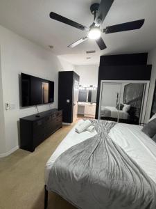 a bedroom with a large bed and a flat screen tv at Cozy Disney Stay in Kissimmee