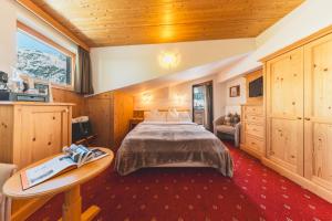 a bedroom with a bed and a table in a room at Haus Melitta in Lech am Arlberg