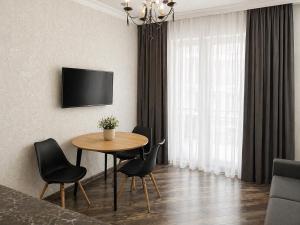 a living room with a table and chairs and a television at Home Inn Apartments Your house Jikia-Central Tbilisi in Tbilisi City