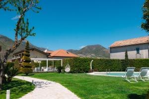 a yard with two lawn chairs and a swimming pool at Divina Costiera in Agerola