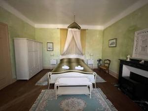 a bedroom with a bed with a canopy and a fireplace at Château Borie Neuve in Badens