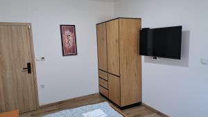 a living room with a tv and a cabinet at Sobe Magnolija, self check-in in Vinkovci