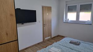 a room with a flat screen tv on a wall at Sobe Magnolija, self check-in in Vinkovci +16 photos