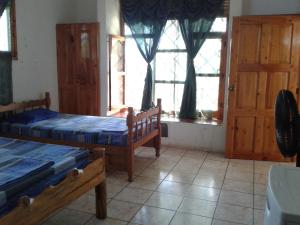 1 dormitorio con 2 camas y ventana en Villa Tortugas en Monterrico