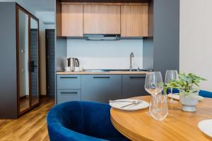 a kitchen with a wooden table and blue chairs at Apartments in Navi in Gonio