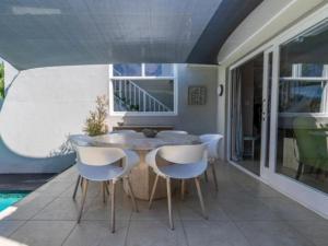 a dining room with a table and chairs on a patio at Hout Bay Gem 61 Milner in Hout Bay