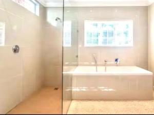 a bathroom with a shower and a tub and a sink at Hout Bay Gem 61 Milner in Hout Bay