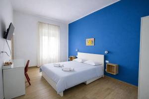 a blue bedroom with a white bed and a blue wall at A Casa di Marco in Capua