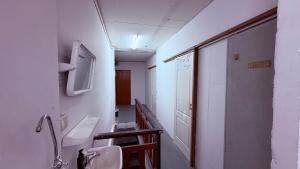 a bathroom with two sinks and a hallway with a tv at Pink Kraken Hostel in Ban Nong Chaeng