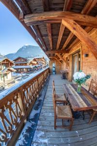 a wooden deck with a wooden table and chairs at Morzine Centre Apartment 1 min from Super M in Morzine