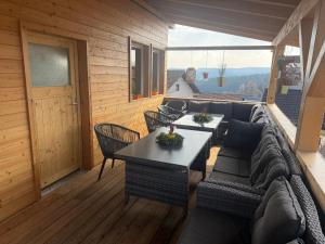 a living room with a couch and tables on a deck at Ferienwohnungen Rauch in Regen