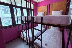 two bunk beds in a room with pink walls at Pink Kraken Hostel in Ban Nong Chaeng