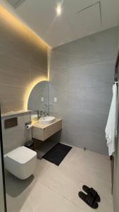 a bathroom with a white toilet and a sink at إستراحة نمارق in Al ‘Aqar +34 photos