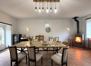 a dining room with a table and chairs and a fireplace at Maison luzouÉ in Cardesse