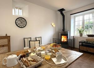 a dining room with a table with bread and a fireplace at Maison luzouÉ in Cardesse +42 photos