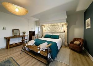 a bedroom with a large bed and a chair at Maison luzouÉ in Cardesse