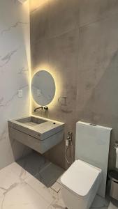 a bathroom with a sink and a toilet and a mirror at إستراحة نمارق in Al ‘Aqar