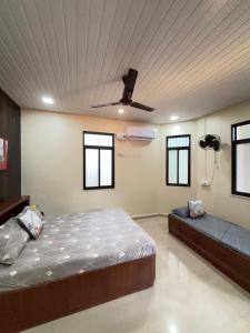 a bedroom with a bed and a ceiling fan at Lilly Beach House in Kīhīm