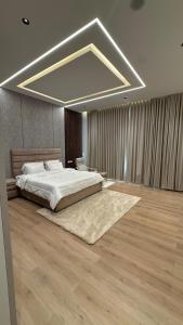 a large bedroom with a large bed and a large chandelier at إستراحة نمارق in Al ‘Aqar