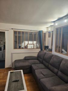 a living room with a couch and a table at Nuits Dijon Chambre in Dijon