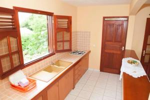 eine große Küche mit Spüle und Fenster in der Unterkunft Casa Sergio in Le Moule
