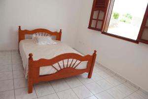 ein Schlafzimmer mit einem Holzbett in einem Zimmer in der Unterkunft Casa Sergio in Le Moule