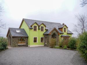 a green house with a black roof at Just Beyond Dingle in Dingle