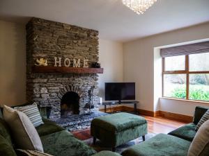 a living room with a couch and a stone fireplace at Just Beyond Dingle in Dingle