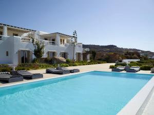 a swimming pool with chairs and a villa at ABSOLUTE PARADISE in Paradise Beach