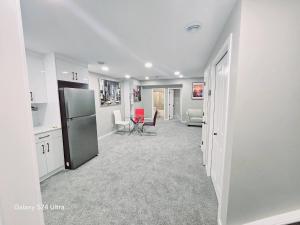 a kitchen with a refrigerator and a living room at Private, Cozy, Luxury, Spacious One Bedroom Suite in Airdrie