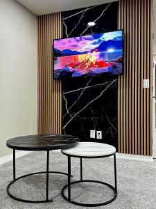 a table in a room with a tv on a wall at Private, Cozy, Luxury, Spacious One Bedroom Suite in Airdrie