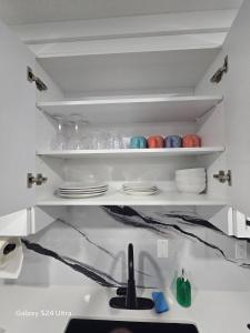 a kitchen shelf with plates and bowls on it at Private, Cozy, Luxury, Spacious One Bedroom Suite in Airdrie +12 photos