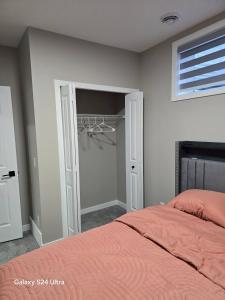 a bedroom with a bed and a closet at Private, Cozy, Luxury, Spacious One Bedroom Suite in Airdrie