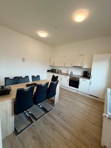 a kitchen with a large wooden table and black chairs at Business Unterkunft Balje 567 - Monteur- & Ferienwohnung mit 7 Einzelbetten in Balje