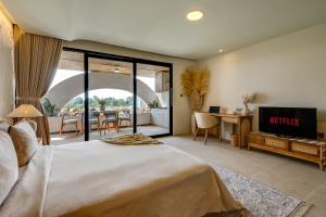 a bedroom with a king sized bed and a television at Premaloka in Tanah Lot