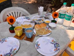 a table with plates and bowls of food on it at Lilly Beach House in Kīhīm