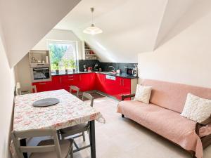 a kitchen with red cabinets and a table and a couch at Atik V Borovičkách in Lipuvka